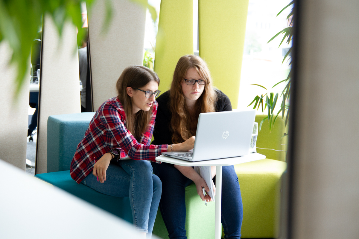 Zwei Kolleginnen arbeiten gemeinsam in der TOPPAN Digital Language-Worklounge am Laptop